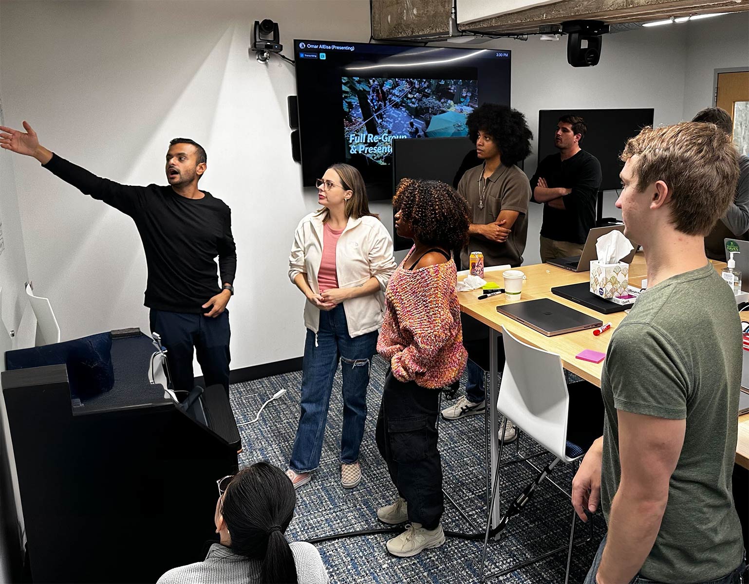 Picture of Omar pointing at a whiteboard